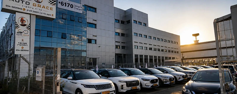 מגרש הרכבים של אוטו גרייס בשקיעה — מבחר רכבים חונים מול בניין הסוכנות בראשון לציון