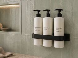 spa amenities — Rosemary Mint body wash, conditioner and shampoo in a wall rack