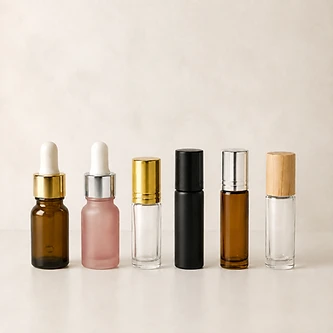 Small glass dropper and roll-on bottles in amber, frosted and clear