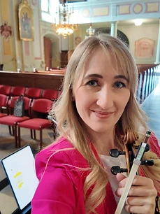 Julia mit Violine in einem pinken Blazer in der Kirche