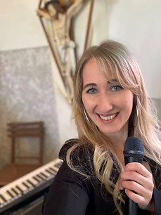 Julia mit Mikrofon vor dem Kruzifix in der Kirche