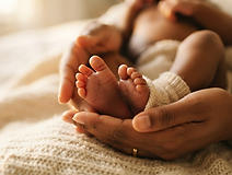 Newborn feet held in a mother's hands