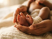 Newborn feet held in a mother's hands