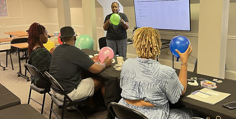 Childbirth educator teaching a class of expectant parents during a labor stages activity