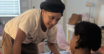 Doula leaning in to encourage a laboring mother at a home birth