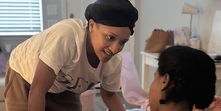 Doula leaning in to encourage a laboring mother at a home birth