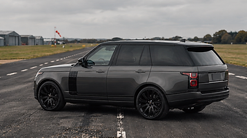 Black Range Rover SUV angled left on an airfield