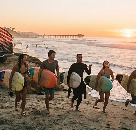 Surfers running to the Pacific