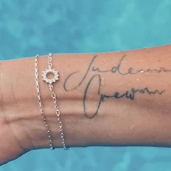 Silver permanent bracelet with crystal sunburst charm and fine silver chain with cursive name tattoo by Oh She Linked