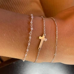 Three stacked silver permanent bracelets with pink beads and cross charm by Oh She Linked