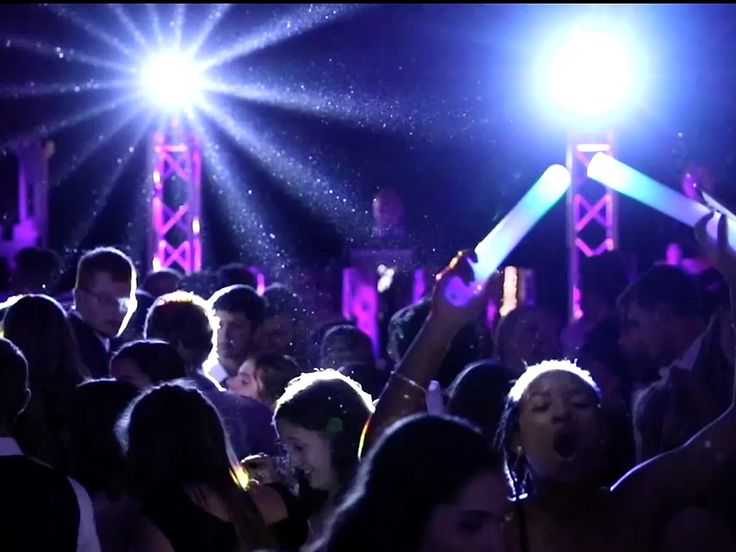 Crowded dance floor under purple and blue nightclub-style lighting
