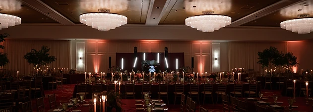Grand ballroom at Turning Stone Resort Casino set for a wedding reception with crystal chandeliers and amber uplighting