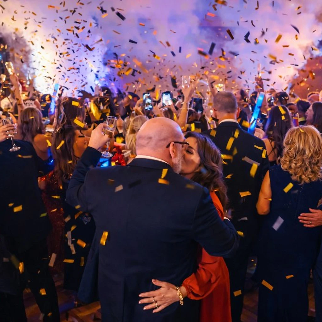 Bride and groom dipping amid cold sparks and low fog in an elegant ballroom