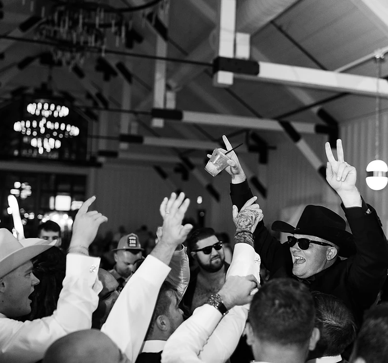 Guests celebrating with hands in the air at a lively event reception