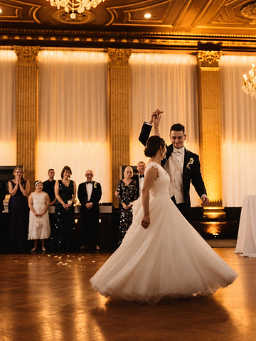 Kristin mid-twirl during her first dance with Corey as guests line the ballroom behind them
