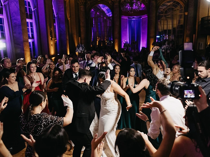 A packed dance floor full of guests celebrating at a luxury wedding reception