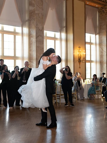 Guests circling the dance floor as Madelyn and Conlan share a mid-lift kiss