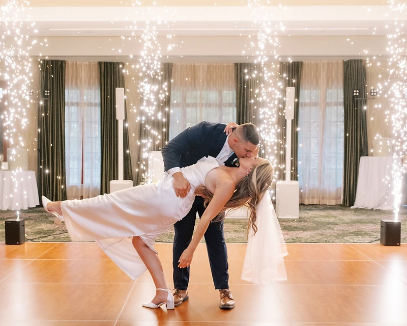 Newlywed couple kissing amid cold sparks on the dance floor at a DJ Mike Melice wedding
