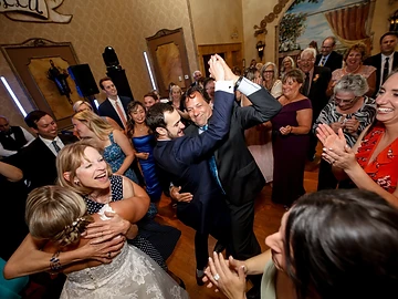 Guests dancing together on a packed dance floor beneath blue LED light bars at a Ventosa Vineyards wedding reception