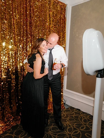 Couple at the Social Booth with a gold sequined backdrop during their Timber Banks Country Club wedding