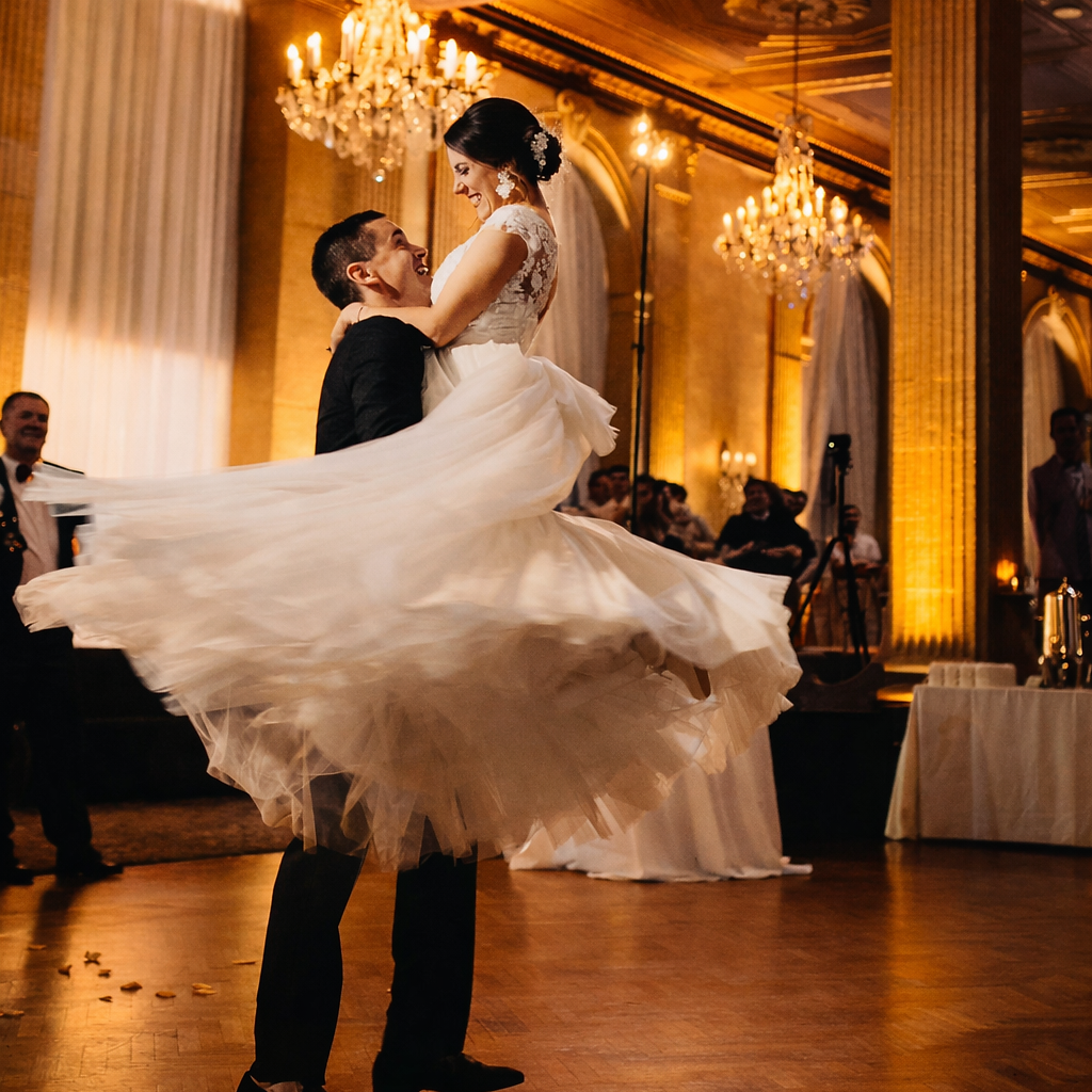 Groom holding his bride amid cold sparks on the dance floor