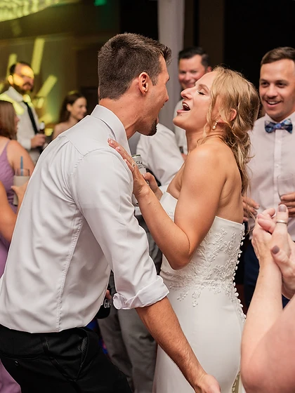 Bride and groom laughing together while dancing at their wedding reception