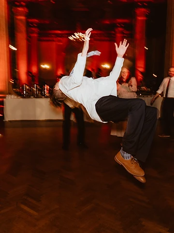 A guest performing a backflip on the dance floor during Kristin and Corey's reception