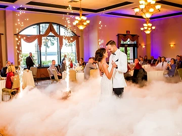 Cold spark fountains and low-lying fog surrounding a bride and groom's first dance in the Meritage Ballroom at Belhurst Castle