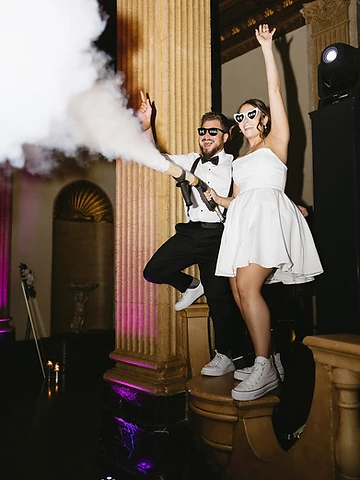 Ryan firing the handheld CO2 cannon as Brittany dances under magenta uplighting in the Persian Terrace