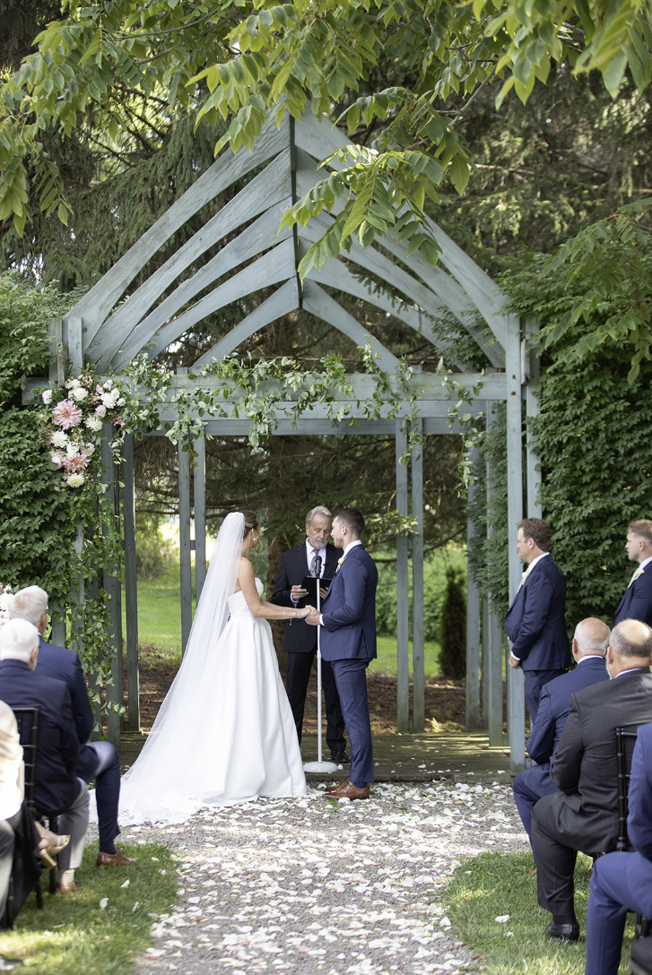 Tented reception setup with long tables, greenery centerpieces, and string lights at John Joseph Inn in Groton, near Ithaca
