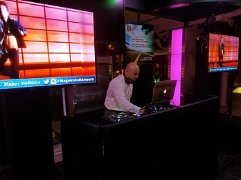 DJ performing with multimedia screens and custom visuals at a private event