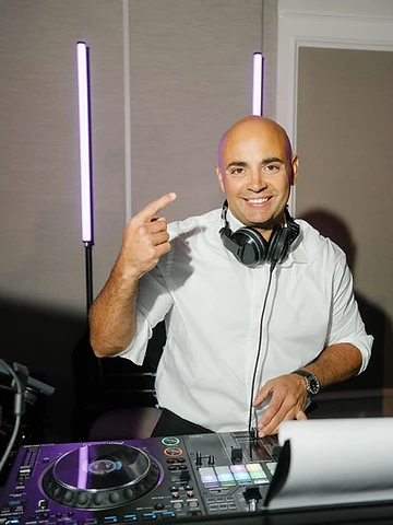 DJ Mike Melice behind the booth with purple LED lighting at a Timber Banks Country Club wedding