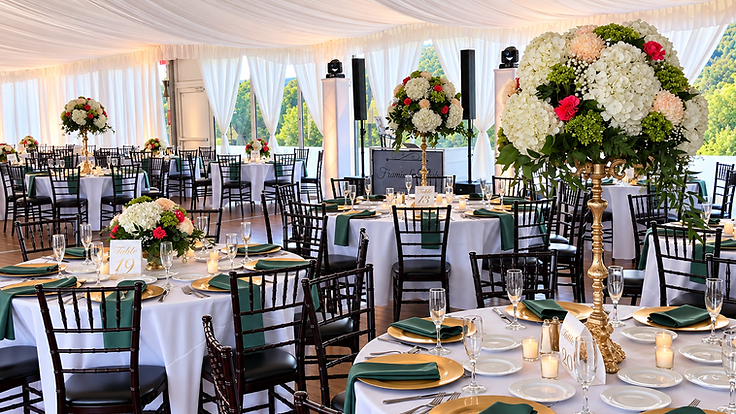 Tented wedding reception at the Meteora Center at Greek Peak Mountain Resort with white drapery, gold centerpieces and mountain views