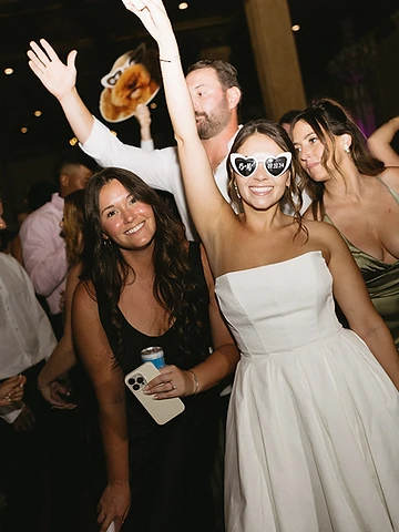Brittany wearing B+R heart sunglasses celebrating with guests on the dance floor