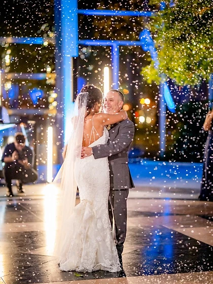 Couple in a romantic first dance as falling snow drifts over a patterned dance floor