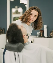 Equipa e cliente especial na barbearia com oferta de camisola assinada