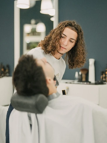 Equipa e cliente especial na barbearia com oferta de camisola assinada