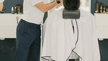 Barbeiro a pentear e finalizar corte de cabelo