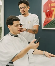 Zona de espera com cliente ao telefone e receção ao fundo