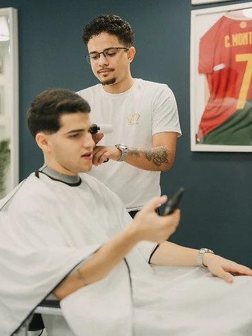 Zona de espera com cliente ao telefone e receção ao fundo