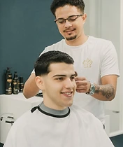 Barbeira a tratar e definir barba de cliente reclinado
