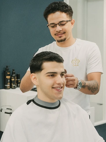 Barbeira a tratar e definir barba de cliente reclinado