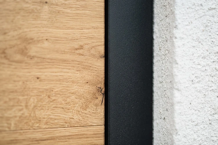 Material detail of oak wood meeting a black steel frame