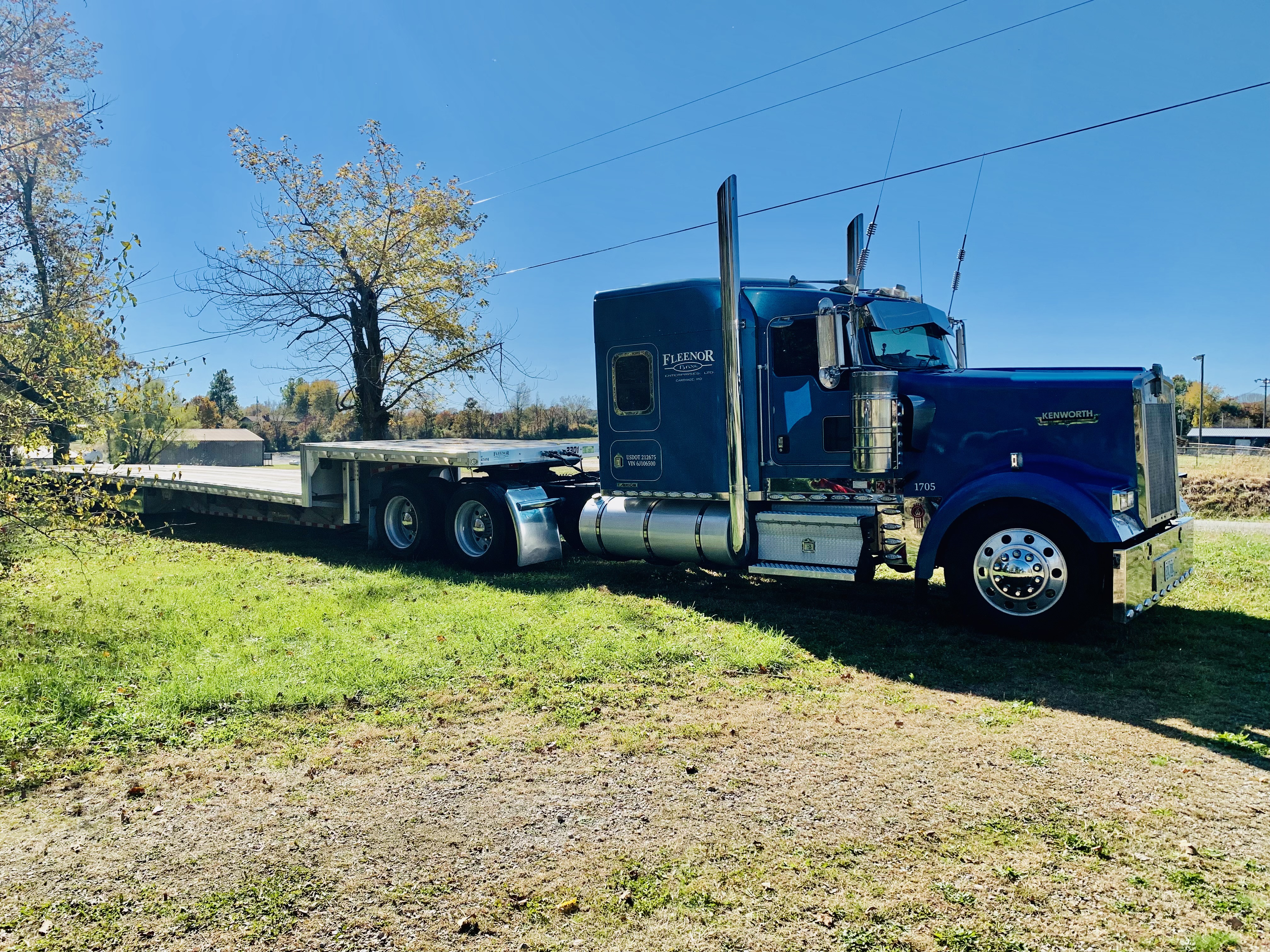 Blue Kenworth semi-truck with a flatbed trailer washed by A&P Wash Services