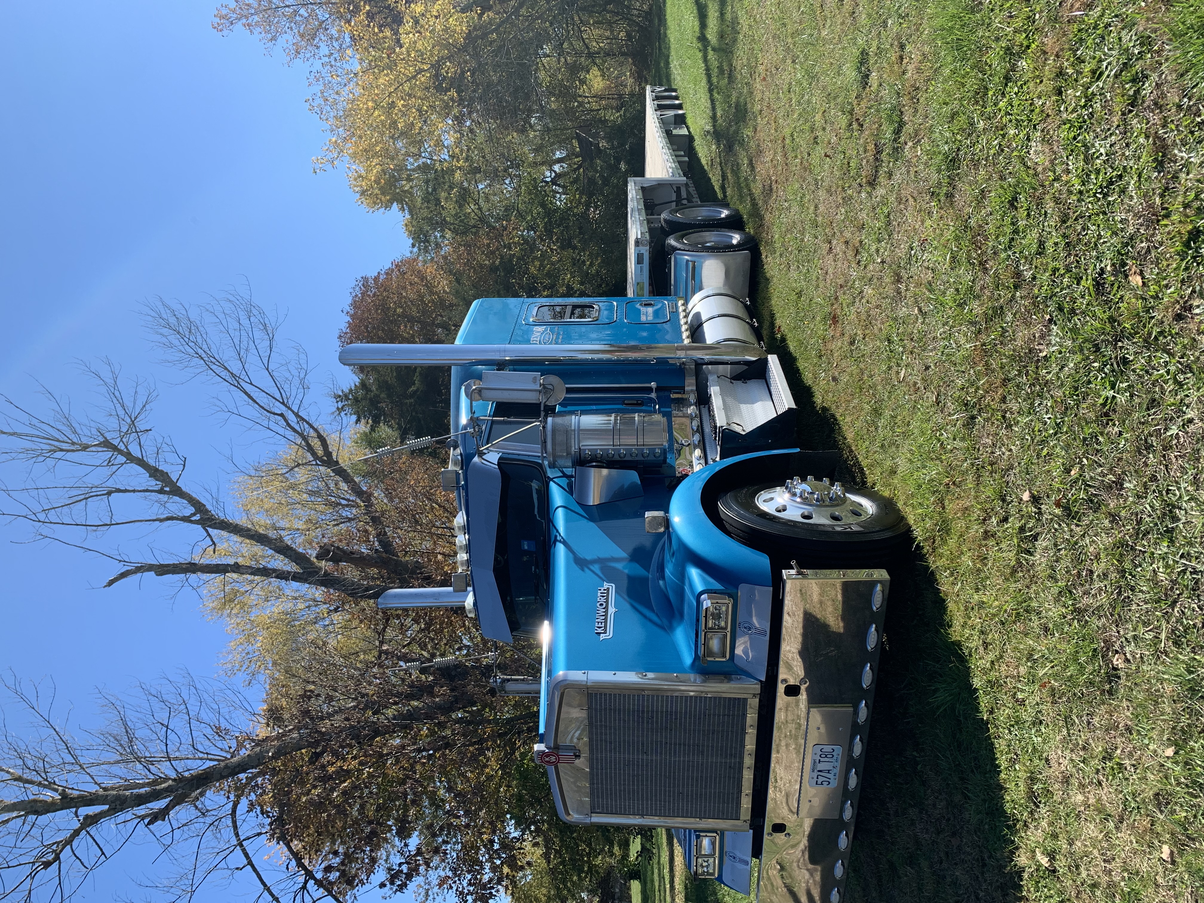 Blue Kenworth semi-truck with flatbed trailer angled view after fleet washing by A&P Wash Services