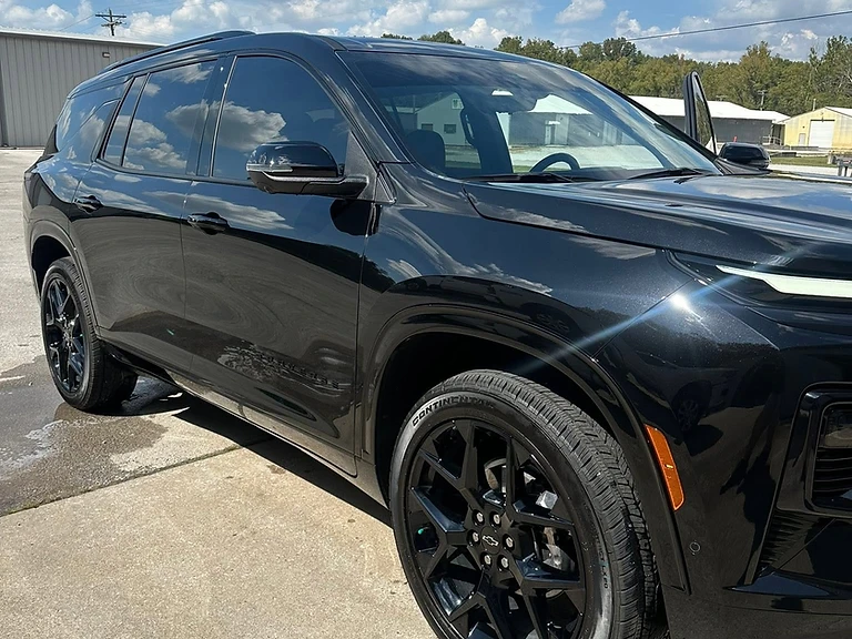 Glossy black Chevrolet SUV detailed to a mirror finish outdoors on a sunny day