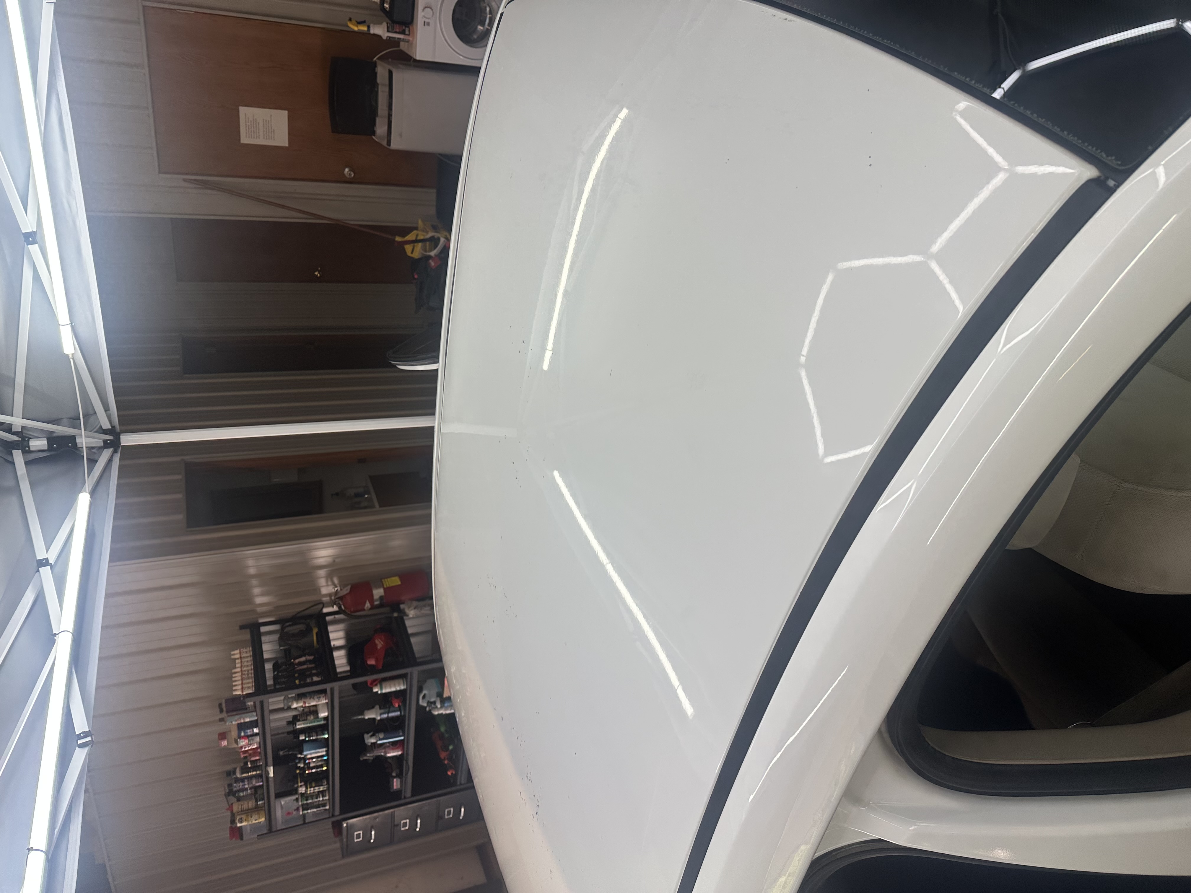 Reflective vehicle roof showing workshop LED lighting after detailing