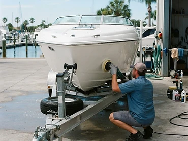 Pristine white boat hull with a glossy gel coat finish being detailed by a professional