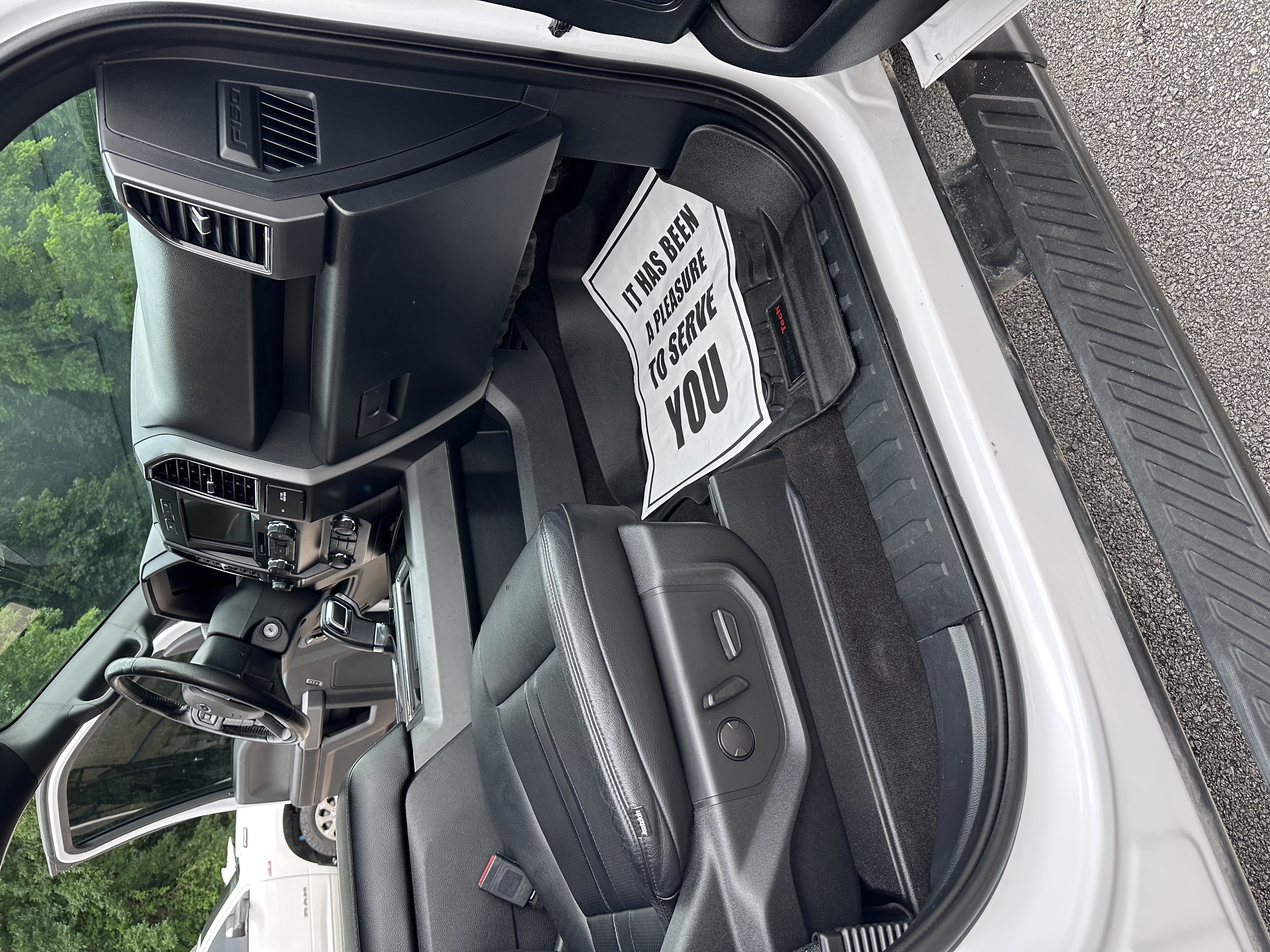 Detailed truck interior with a protective floor mat reading it has been a pleasure to serve you