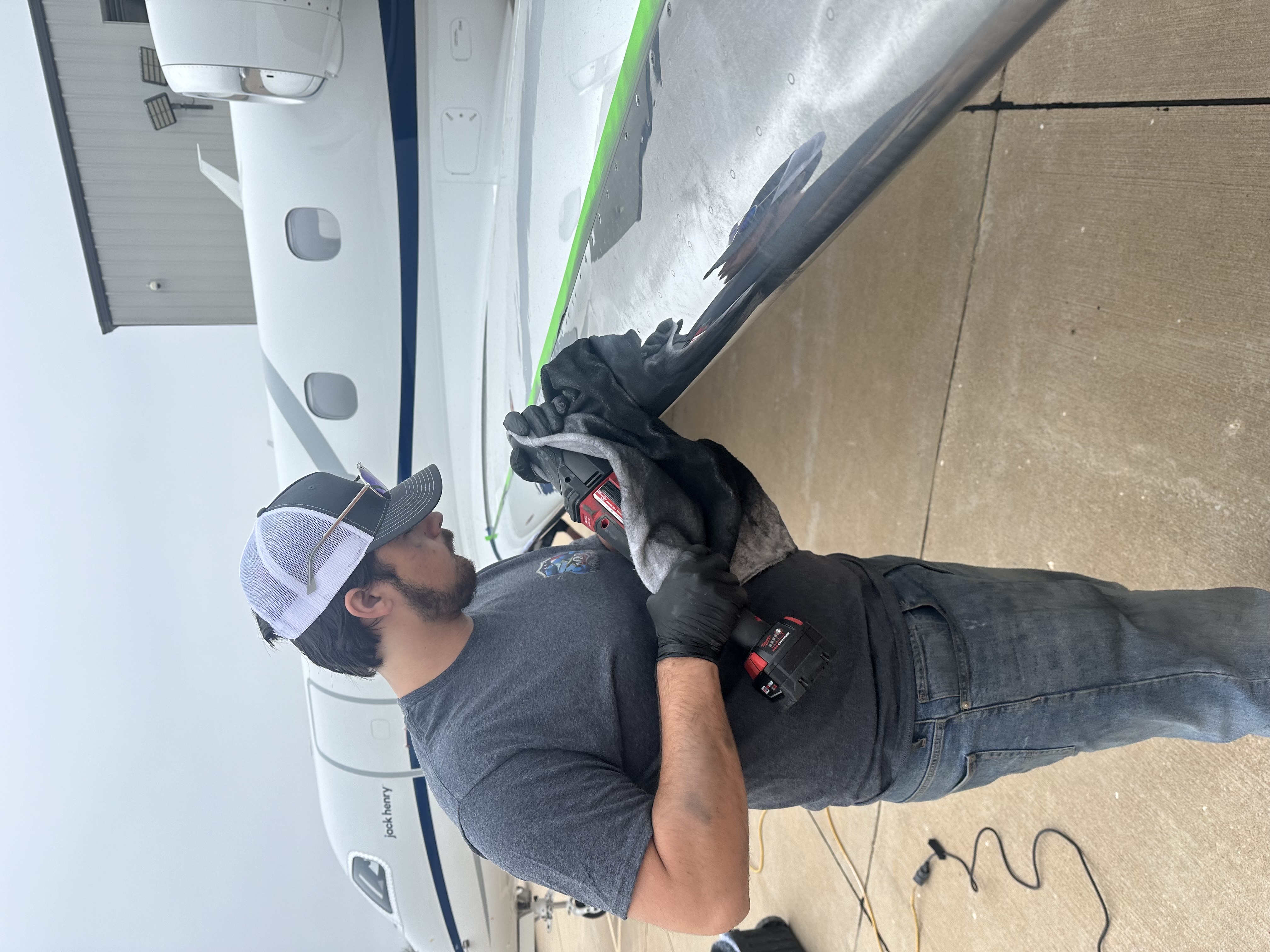 A&P technician polishing the leading edge of an aircraft wing